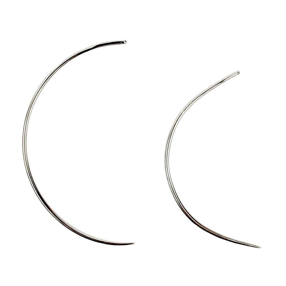 Two curved hair extension needles on a white background