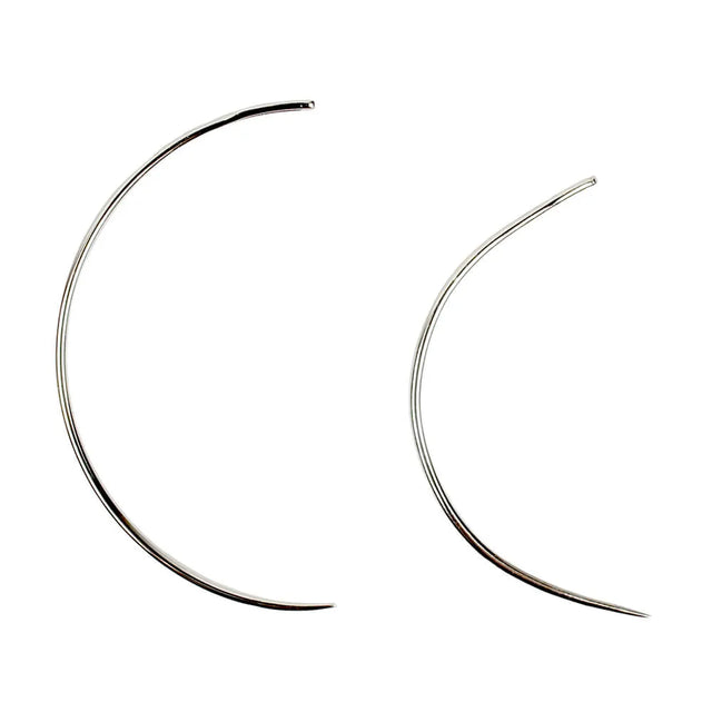 Two curved hair extension needles on a white background