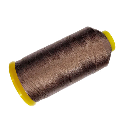 Spool of brown thread with a yellow core on a white background