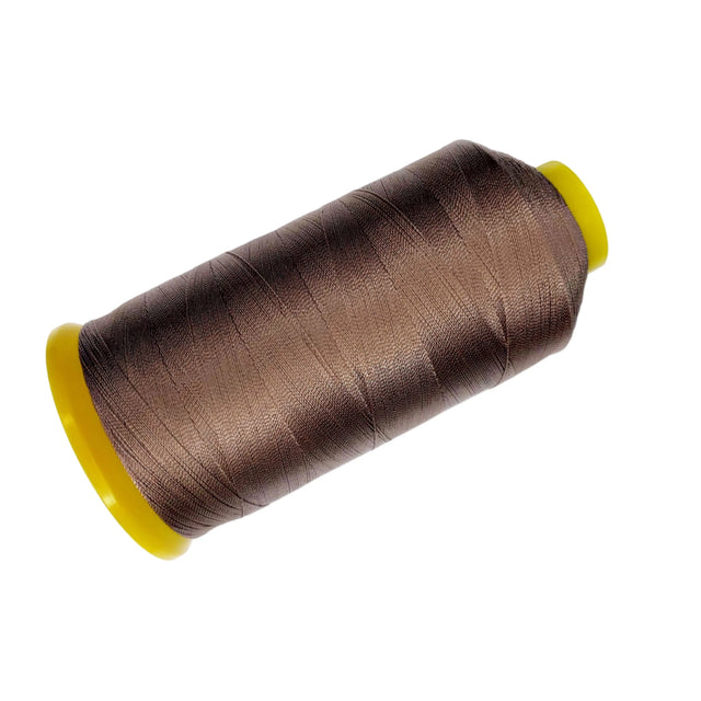 Spool of brown thread with a yellow core on a white background