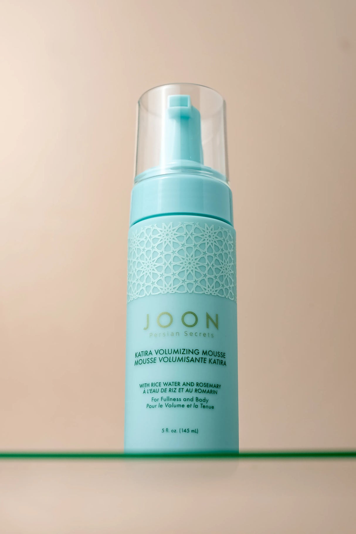 Close-up of Katira Volumizing Mousse bottle with a sleek, clean appearance.