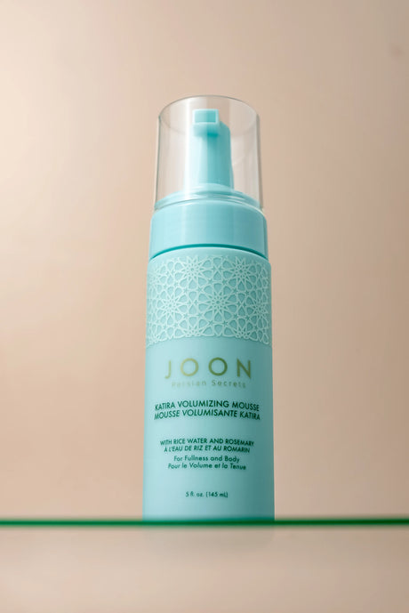 Close-up of Katira Volumizing Mousse bottle with a sleek, clean appearance.