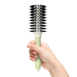 A model holds the Olivia Garden Round Smoothing Brush. 